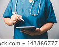 Healthcare professional holding a digital tablet and stylus pen, representing electronic health records, telemedicine, digital documentation, and modern medical technology. 143886777
