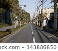 A straight city street in Tokyo lined with street trees. 143886850