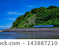 Local diesel railcars running along the coastline 143887210
