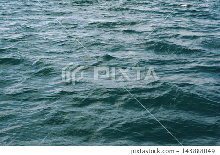 Blue abstract texture with waves on the sea. Background with ocean waves and ripples Blue abstract texture with waves on the sea. Background with ocean waves and ripples 143888049
