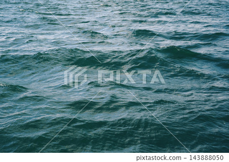 background with blue sea waves on water surface. Texture of the ocean waves. 143888050