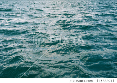 Blue abstract texture with waves on sea. Background with ocean waves and ripples 143888051