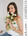 Woman Holding White Tulips Bouquet Near Face 143889219