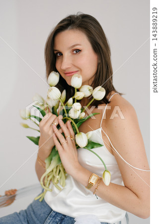 Woman Holding White Tulips Bouquet Near Face 143889219