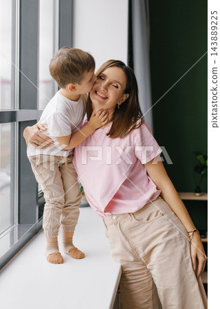 Toddler Boy Kissing His Smiling Mother on the Cheek at Home Toddler Boy Kissing His Smiling Mother on the Cheek at Home 143889225