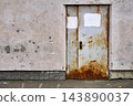 Old rusty metal doors on a battered wall 143890037