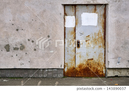 Old rusty metal doors on a battered wall Old rusty metal doors on a battered wall 143890037