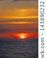 Fiery red sunset and layered clouds over the sea at Badesi 143890232