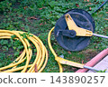 Summer irrigation.Watering rubber hose reel lying on grass 143890257