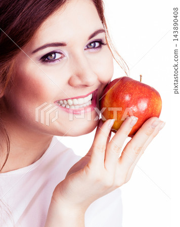 Woman holds apple fruit close to face, isolated Woman holds apple fruit close to face, isolated 143890408