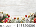Christmas greenery and ornaments framing a whitewashed wooden background 143890800