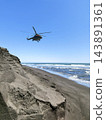 A Russian National Guard multi-purpose helicopter from the Mi-8 family flies over Khalaktyrsky Beach at an extremely low altitude in clear weather. Kamchatka, Russia. 143891361