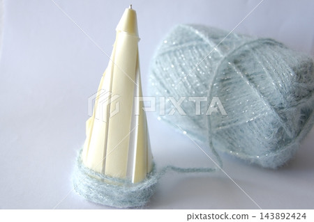從圓錐體底部開始纏繞紗線的過程。 從圓錐體底部開始纏繞紗線的過程。 143892424