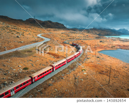 Aerial view of red train near azure mountain lake in autumn 143892654
