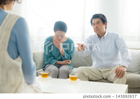 一對老年夫婦和他們的女兒召開家庭會議。 一對老年夫婦和他們的女兒召開家庭會議。 143892657