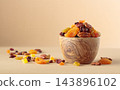 Assorted nuts and dried fruits in wooden bowl on  a beige background. 143896102