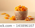 Organic dried apricots in wooden bowl on  a beige background. 143896107