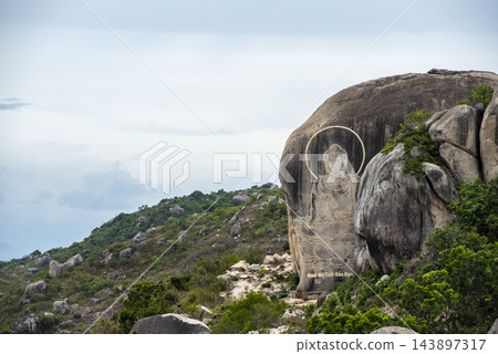 A Buddha carving etched into a massive granite rock on a mountain in Vietnam. 143897317