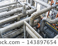 Intricate industrial metal pipeline system inside a factory facility 143897654