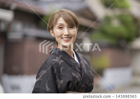 一位五十多歲的女性身穿越後夏季和服,微笑著直視鏡頭,她的肖像照。 一位五十多歲的女性身穿越後夏季和服,微笑著直視鏡頭,她的肖像照。 143898563