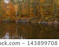 Autumn Forest Reflected Across Quiet Lake. Peaceful autumn nature concept symbolizing seasonal transformation harmony and beauty of untouched landscapes 143899708