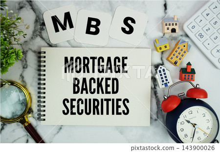 MBS Mortgage-Backed Securities text written on notepad with house model, calculator, magnifying glass and alarm clock on marble background MBS Mortgage-Backed Securities text written on notepad with house model, calculator, magnifying glass and alarm clock on marble background 143900026
