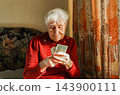 Joyful mature woman holding money 143900111