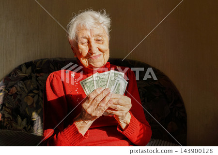 Joyful mature woman holding money Joyful mature woman holding money 143900128