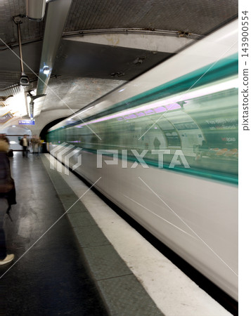 Paris Metro train arriving at a station, captured with intentional motion blur as an artistic photographic technique, creating dynamic light trails and a sense of movement on the platform. High Paris Metro train arriving at a station, captured with intentional motion blur as an artistic photographic technique, creating dynamic light trails and a sense of movement on the platform. High 143900554