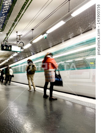 Paris Metro train arriving at a station, captured with intentional motion blur as an artistic photographic technique, creating dynamic light trails and a sense of movement on the platform. High Paris Metro train arriving at a station, captured with intentional motion blur as an artistic photographic technique, creating dynamic light trails and a sense of movement on the platform. High 143900556