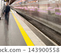 Paris Metro train arriving at a station, captured with intentional motion blur as an artistic photographic technique, creating dynamic light trails and a sense of movement on the platform. High 143900558