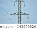 Close up shot of high voltage power line steel lattice tower crossarm with insulators against clear blue sky background 143900620