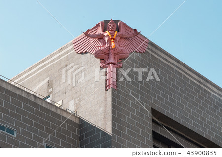 Art Deco Garuda Sculpture on Modernist Thai Architecture with Marigold Garland and gripping a traditional bugle, powerfully mounted on the corner facade of the historic Grand Postal Building in Bang Art Deco Garuda Sculpture on Modernist Thai Architecture with Marigold Garland and gripping a traditional bugle, powerfully mounted on the corner facade of the historic Grand Postal Building in Bang 143900835