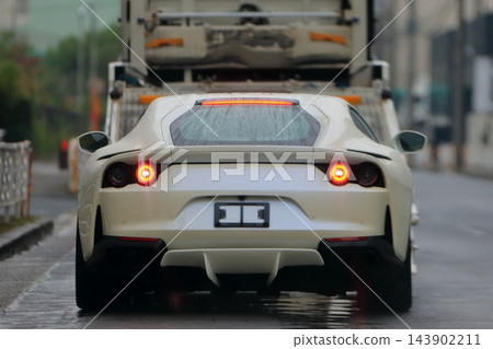 一輛跑車正從汽車運輸車上卸下。 一輛跑車正從汽車運輸車上卸下。 143902211