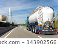 White big modern tanker shipment cargo commercial semi trailer truck moving fast on motorway road city urban suburb. Business distribution logistics service. Lorry driving highway sunny day blue sky 143902566