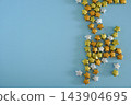 Glitter gold and silver origami lucky stars scattered on pastel blue background with copy space, ideal for festive celebrations 143904695