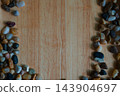 Colorful polished river pebbles arranged at the corner of wooden background  143904697