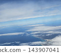 Winding shore between white clouds and blue sea 143907041