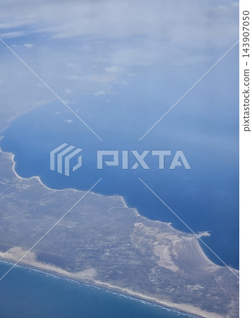 Steep coastal edge and ocean seen from aircraft 143907050