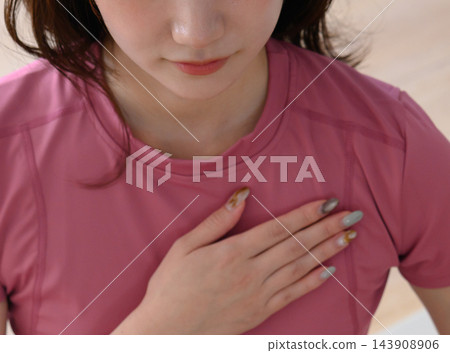 特寫鏡頭:一名女子手放在胸口,深吸一口氣。 特寫鏡頭:一名女子手放在胸口,深吸一口氣。 143908906