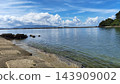 A nostalgic harbor scene with calm waves and a clear blue sky. 143909002
