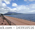Sakurajima volcano and a well-maintained promenade along the coast, viewed across Kinko Bay. 143910516