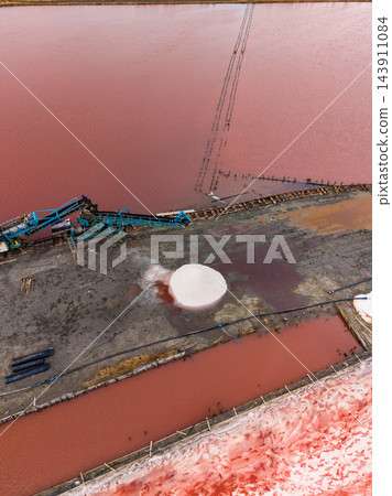 Salt extraction site with processing equipment and salt deposits in outdoor evaporation ponds Salt extraction site with processing equipment and salt deposits in outdoor evaporation ponds 143911084