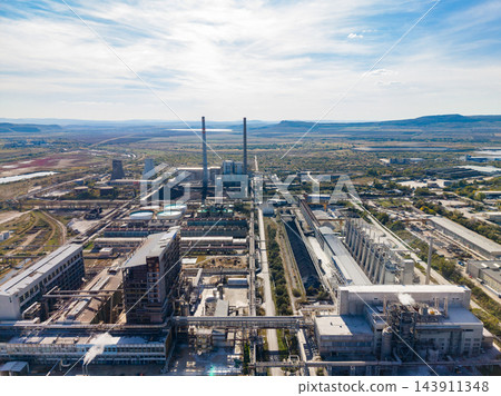 Aerial view of a large industrial plant with smokestacks and factory buildings in a wide valley Aerial view of a large industrial plant with smokestacks and factory buildings in a wide valley 143911348