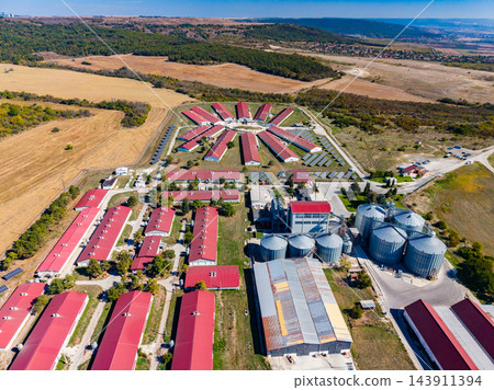 Aerial view of an agricultural complex with grain silos and farm buildings in a rural landscape Aerial view of an agricultural complex with grain silos and farm buildings in a rural landscape 143911394