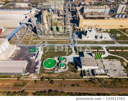 Aerial view of an industrial processing plant with storage tanks and roadways in operation during the day Aerial view of an industrial processing plant with storage tanks and roadways in operation during the day 143911563