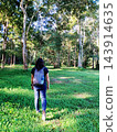 Asian woman with backpack travel and walking into the tropical forest in Thailand 143914635