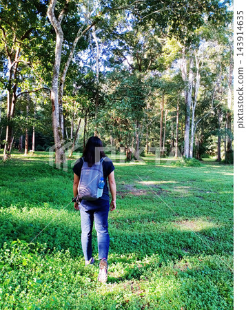 Asian woman with backpack travel and walking into the tropical forest in Thailand Asian woman with backpack travel and walking into the tropical forest in Thailand 143914635