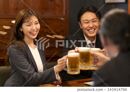 一群勞工階級男女在居酒屋（日本酒吧）碰杯。 143914790