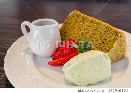 一份甜點拼盤，包括抹茶戚風蛋糕、草莓和冰淇淋。 143916104